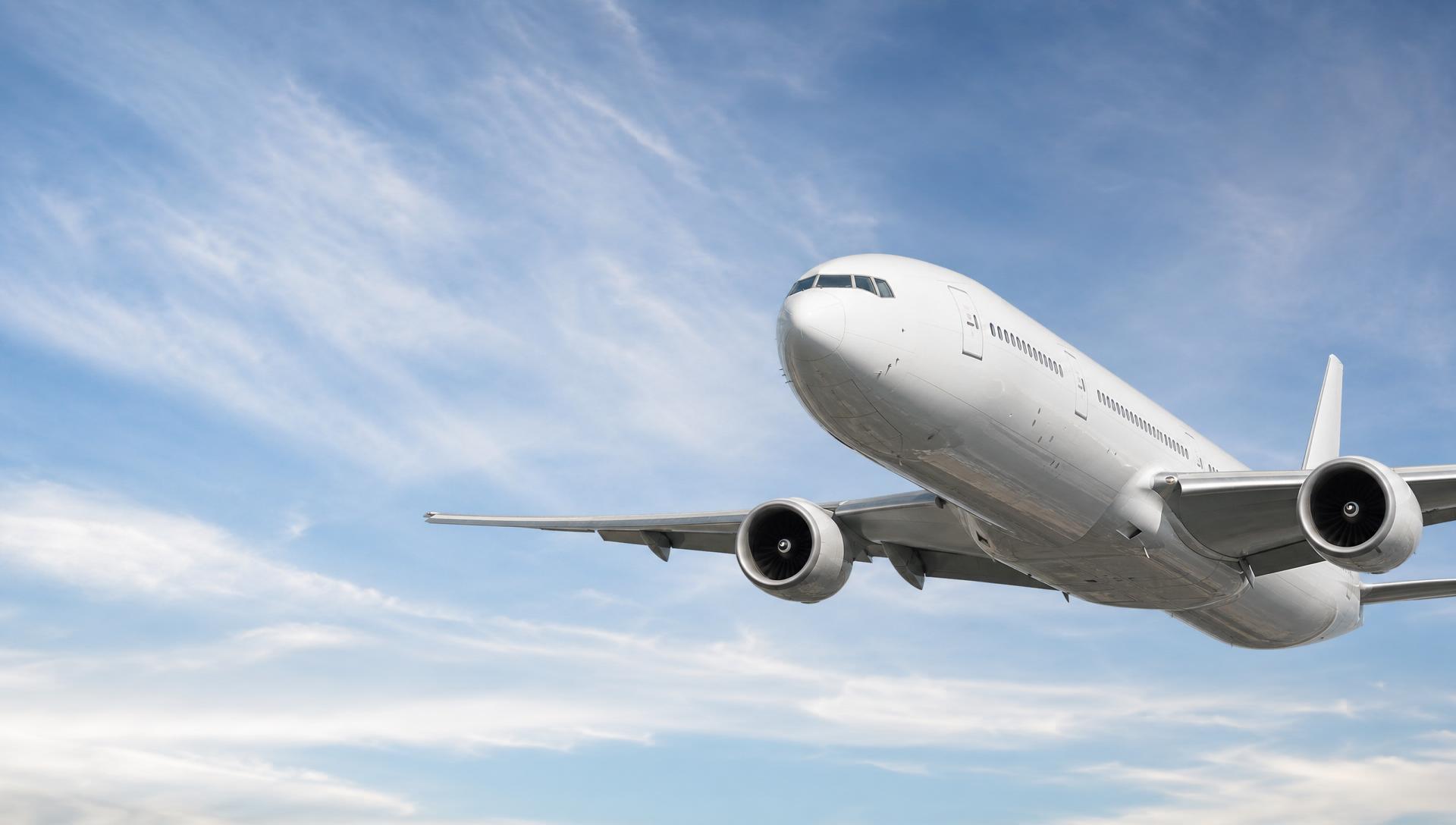 Boeing 777 in flight against a soft sky
